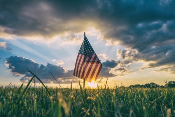 sunrise over field with American Flag